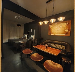 Relax in a stylish seating area with a leather couch and chairs, surrounded by modern art and clean lines.