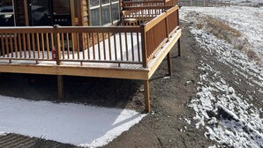 Une rangée de cabanes en bois, dotées de toits en métal, de terrasses en bois et de grandes fenêtres.