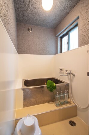 Un baño con bañera, lavamanos y ventana.