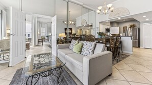 Un salon moderne doté d’une cloison en verre, d’un canapé, d’une table basse et d’un coin repas avec des chaises et une table.