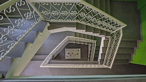 Una escalera de caracol con barandillas de metal ornamentadas y un diseño geométrico.