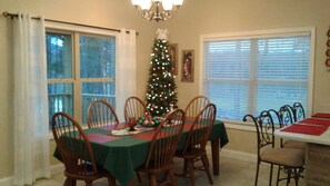 A dining room with a Christmas tree, a chandelier, and a window with blinds. - LAKEFRONT 4/3.5, Private Dock, Pool Table, Lakeside Firepit, Kayaks, Paddleboat (Young Harris)