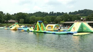 Ein Wasserpark im Freien mit Hüpfburgen und einer Rasenfläche im Hintergrund.