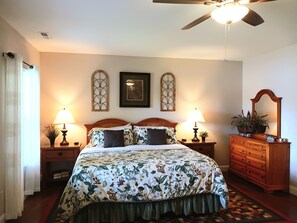 A bedroom with a bed, two bedside tables with lamps, a dresser, a ceiling fan, and decorative wall sconces. - LAKEFRONT 4/3.5, Private Dock, Pool Table, Lakeside Firepit, Kayaks, Paddleboat (Young Harris)