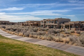 A residential area with modern houses, a paved walkway, and dry shrubbery. - 4BR on the 18th Green - Desert & Mountain Views (St. George)