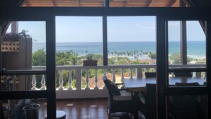 Ein Balkon mit Blick auf das Meer und Palmen.