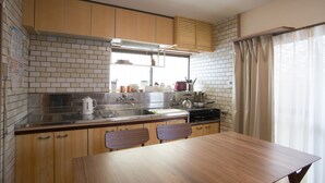 A modern kitchen with wooden cabinets, a stainless steel sink, and a wooden dining table.