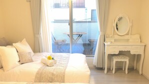 A bedroom with a large bed, a vanity with a mirror, and a view of an outdoor balcony. - All New Beautiful Villa.NearU.S.JNanba (Ōsaka-shi)