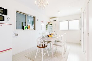 A bright, white dining area with a chandelier, a refrigerator, and a window with a view. - All New Beautiful Villa.NearU.S.JNanba (Ōsaka-shi)