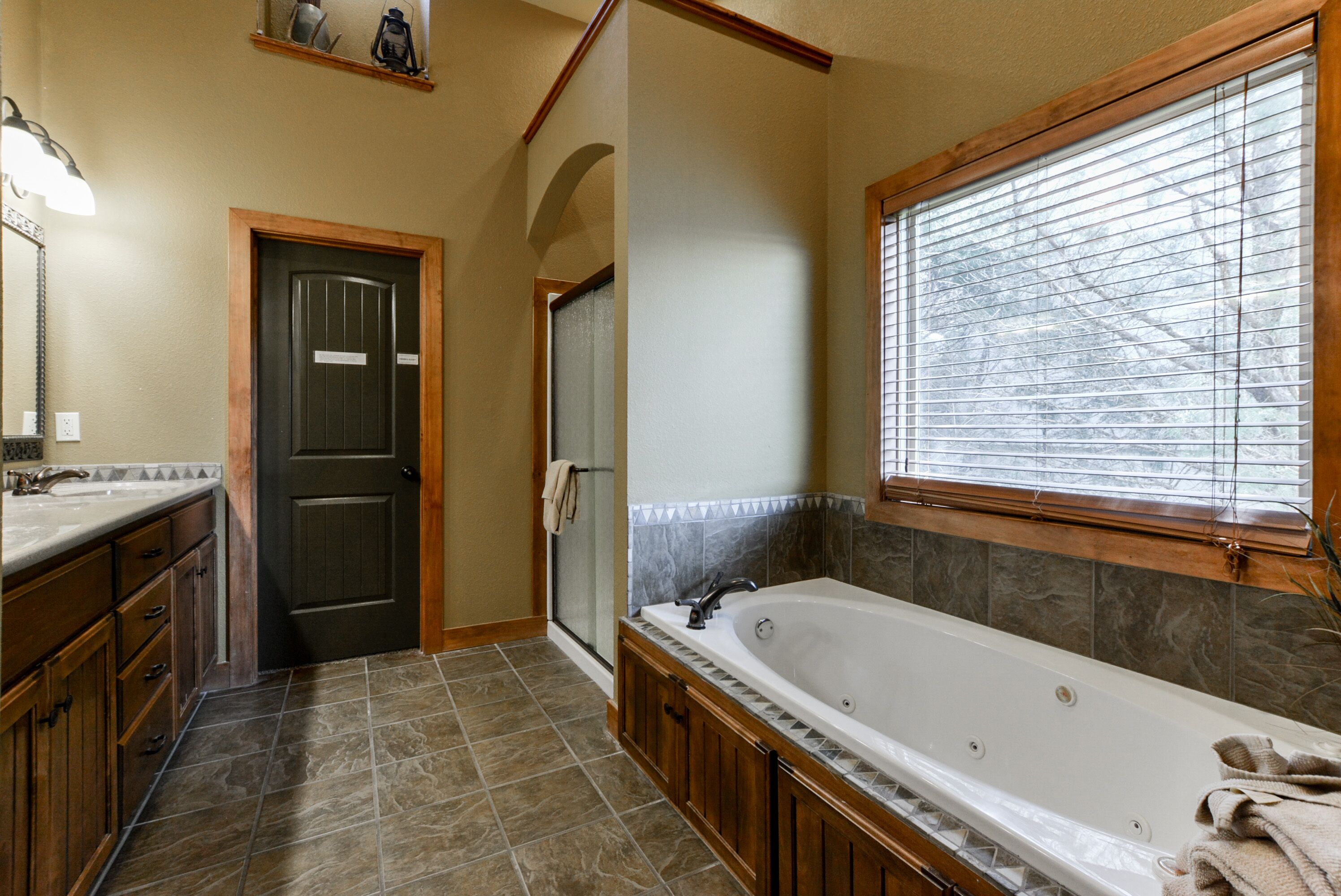 A bathroom with a bathtub, a shower, and a vanity with a sink.
