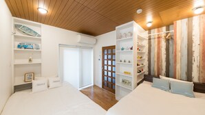 A hotel room with two beds, wooden ceiling, white walls, and a wooden door. - Large city villa near Osaka Castle 5 min (Ōsaka-shi)