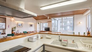 A modern kitchen with a built-in oven, a coffee maker, and a sink with a soap dispenser. - Large city villa near Osaka Castle 5 min (Ōsaka-shi)
