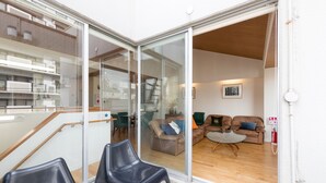 A modern living room with a glass door leading to a kitchen area. - Large city villa near Osaka Castle 5 min (Ōsaka-shi)