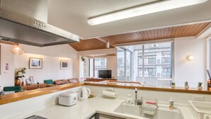 Een moderne keuken met een ingebouwde oven, een koffiezetapparaat en een spoelbak met zeepdispenser.