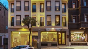 Un hotel con fachada moderna, amplias ventanas y escaparate visible con diversos artículos expuestos.