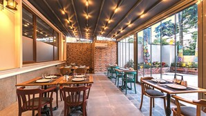 Un restaurante con paredes de ladrillo, mesas y sillas de madera.