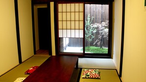 Ein traditioneller japanischer Raum mit Tatami-Bodenbelag, einem niedrigen Holztisch und Shoji-Schiebetüren.