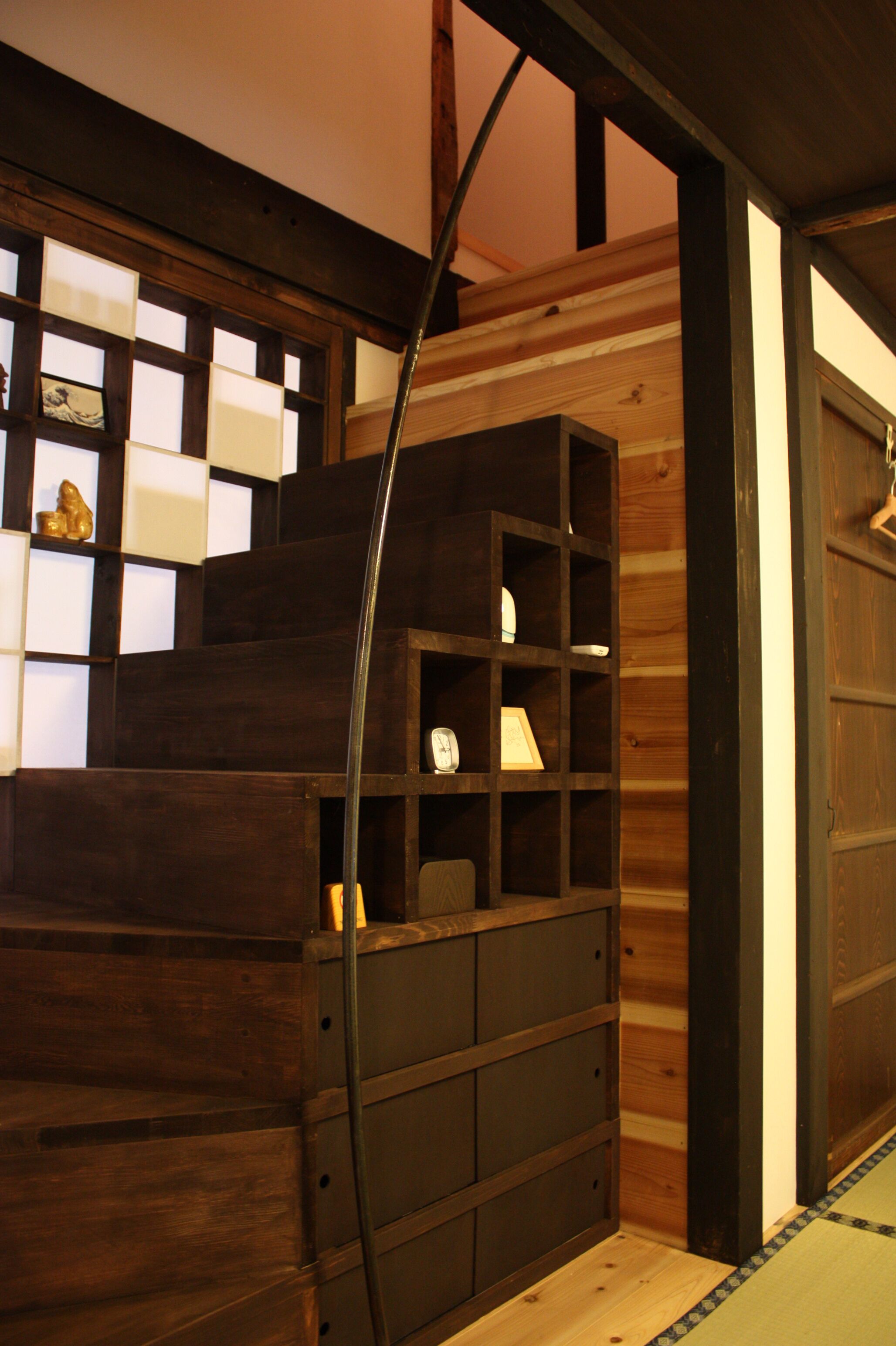 A wooden staircase with built-in shelves and a metal handrail.