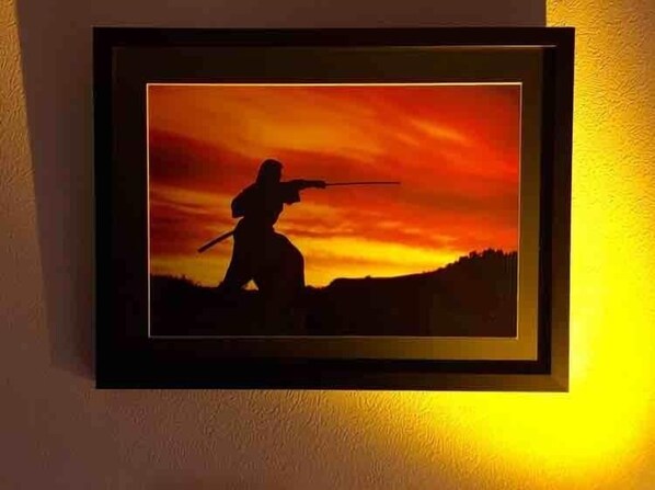 A framed picture of a silhouette of a person in a martial arts pose against a sunset background. - Beautiful Japanese Gardens by Walk (Toshima-ku)