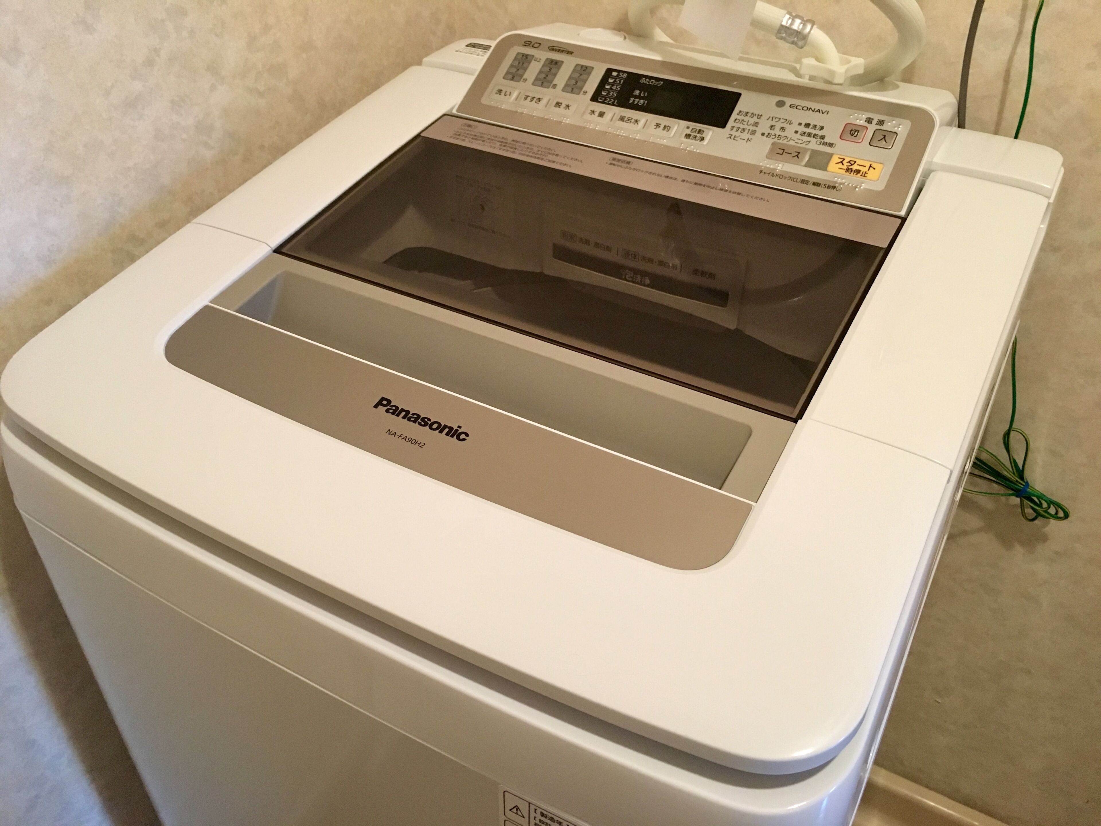 A white Panasonic washer with a digital control panel and a transparent door.