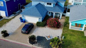 A residential area with houses, a driveway, a car, and a fire hydrant.