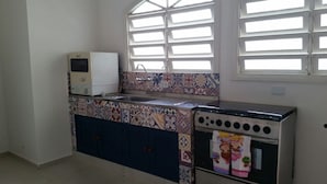 A kitchen with a microwave, oven, and tiled backsplash. - BEAUTIFUL HOUSE WITH AN UNMISSABLE OUTDOOR AREA!!!! (Balneario Guarujá)