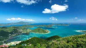 Un paysage côtier avec de nombreuses îles, des eaux d’un bleu limpide et des collines verdoyantes.