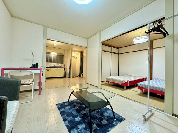 Una habitación compacta con kitchenette, una cama, una silla y una pequeña mesa.