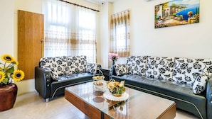 A living room with a sofa, a coffee table, and a painting on the wall. - Aurora Castle (Luodong)
