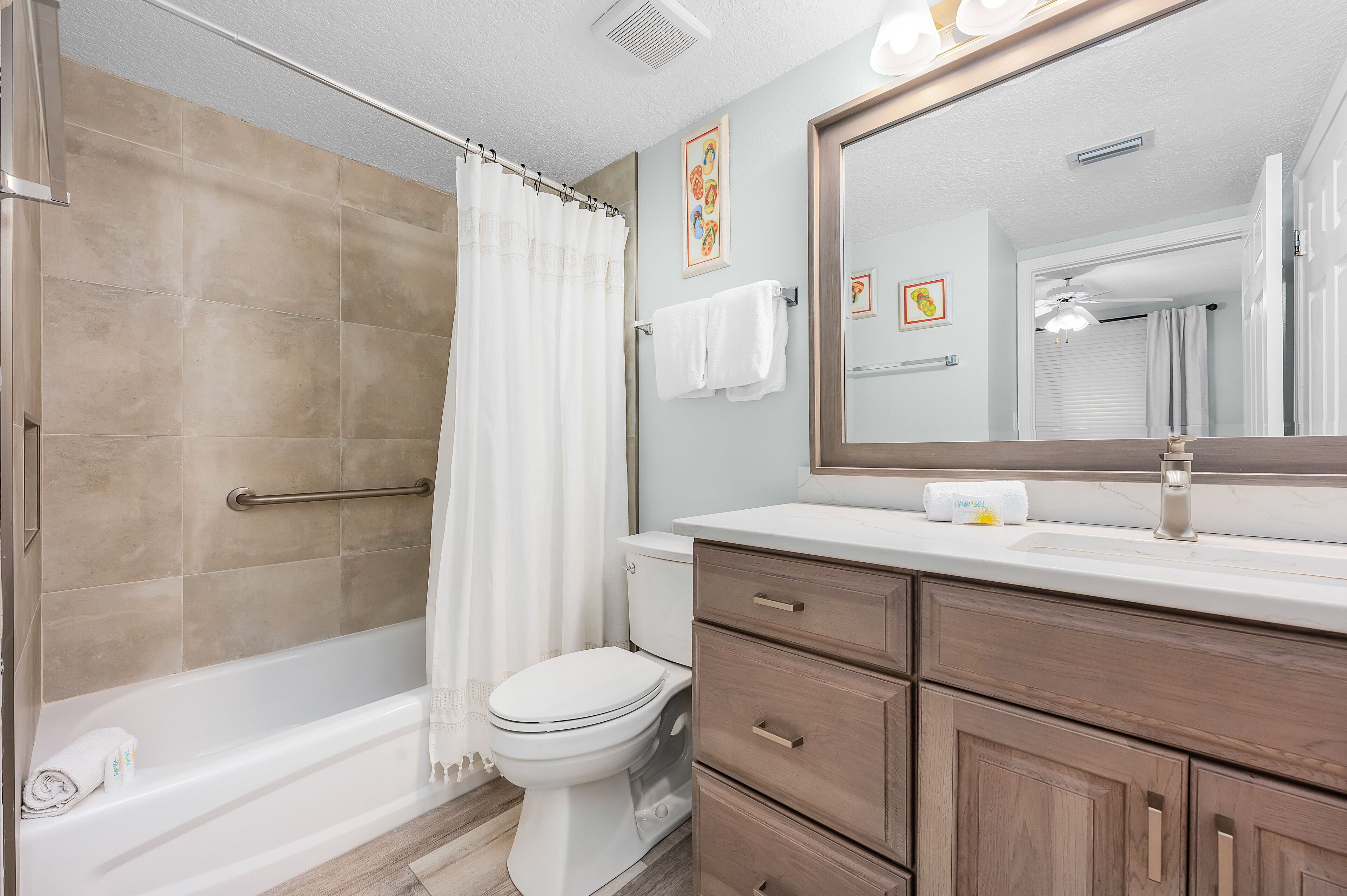 A bathroom with a shower, toilet, and vanity with drawers.