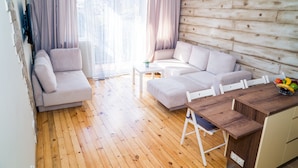Un salon confortable avec un canapé, une table basse et une table à manger en bois.