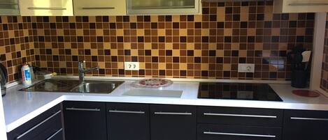 Køleskab, mikrobølgeovn, køkkentøj/tallerkener/redskaber, spisebord