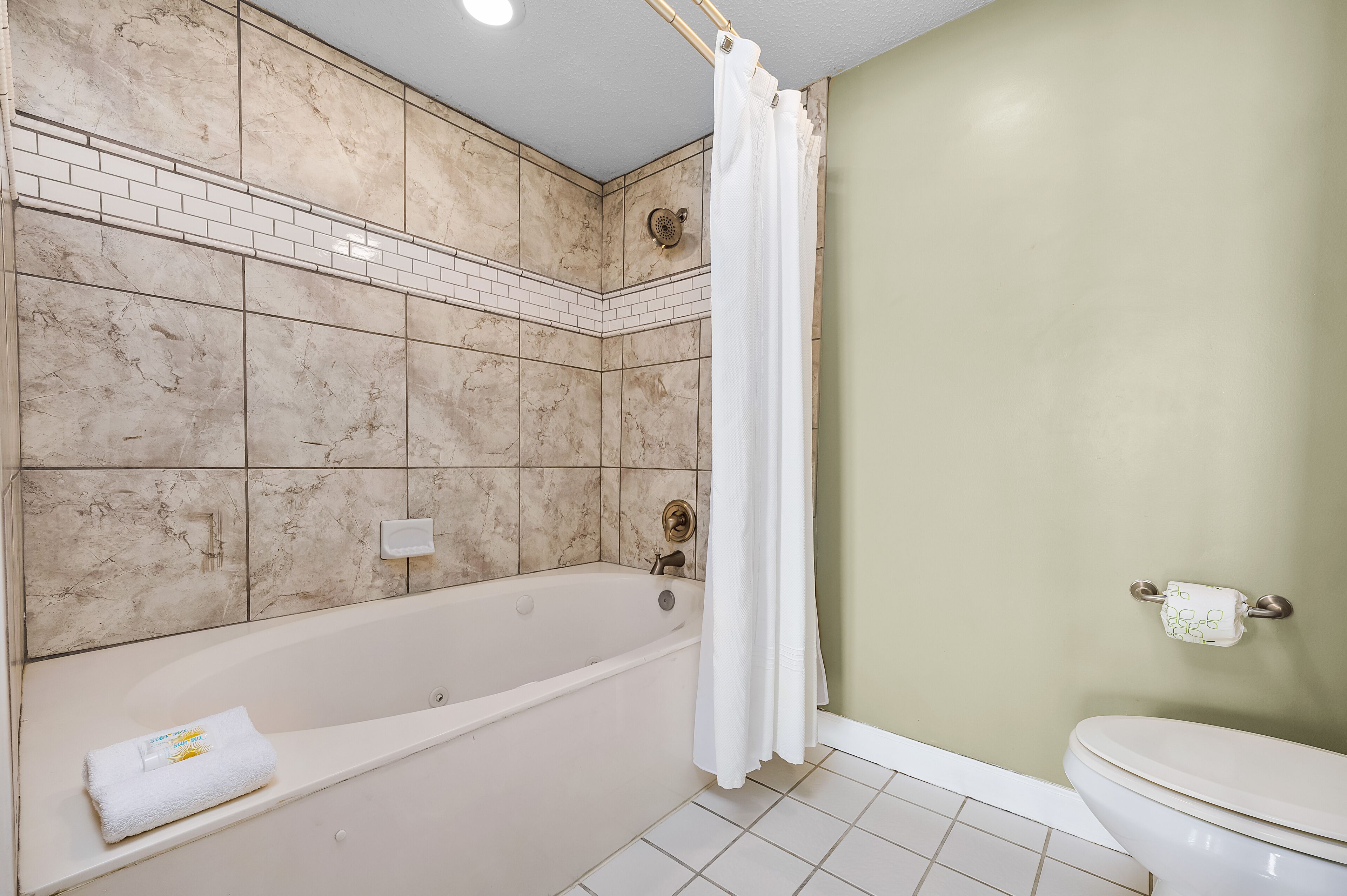 A bathroom with a bathtub, shower, and toilet.