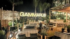 Ein Sitzbereich im Freien mit einer Steinmauer und dem Namen 'GAMMARIS', der im Hintergrund beleuchtet ist.
