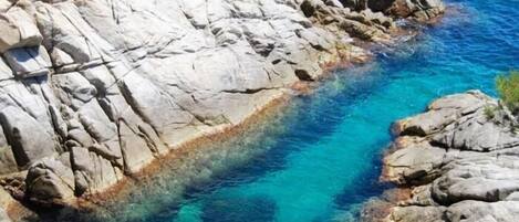 Una costa rocosa con aguas azul cristalino.