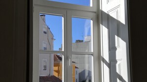 A room with a large window overlooking a street. - Ah33 - Superior Family Apartment - University and Historic Center (Coimbra)