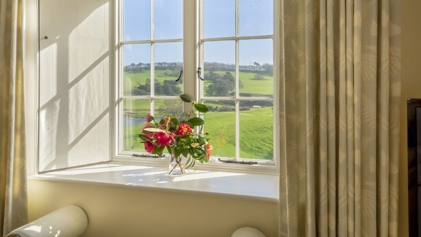 A room with a large window featuring a view of a green landscape. - Spacious, self contained flat within this Historic Castle of Caerhays, within walking distance of th (Saint Austell)