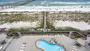 A rooftop pool with a heart-shaped design, surrounded by lounge chairs and a deck area. - Summerwind Resort 602 Center * Beach Chair Set Included * Salt Water Vacations (Navarre)