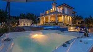 Ein modernes Haus mit Schwimmbad und Sitzbereich im Freien.