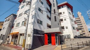 A multi-story building with a red entrance, a visible sign reading "ASTERIA N°5", and a bike parked outside. - N ° 5  CONDOMINIUM: First floor Corner Apartment ;  Safe Residential Area. (Osaka)