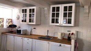 A kitchen with white cabinets, a Bosch dishwasher, a toaster, and a kettle. - Cozy town house in the center of Assens, close to the harbor. (Assens)