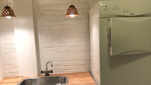 A compact kitchen with a sink, wooden countertop, and a washing machine. - Cozy town house in the center of Assens, close to the harbor. (Assens)