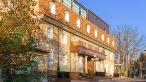 A historic building with a prominent entrance, large windows, and a balcony. - Praga Hotel (Tashkent)