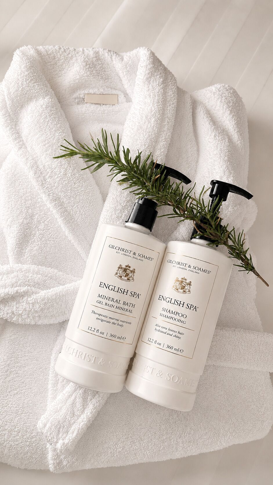 A white bathrobe with two bottles of English Spa Shampoo and Mineral Bath Gel Bain Mineral.