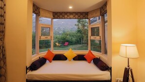A bedroom with a bed, a window, and a lamp.