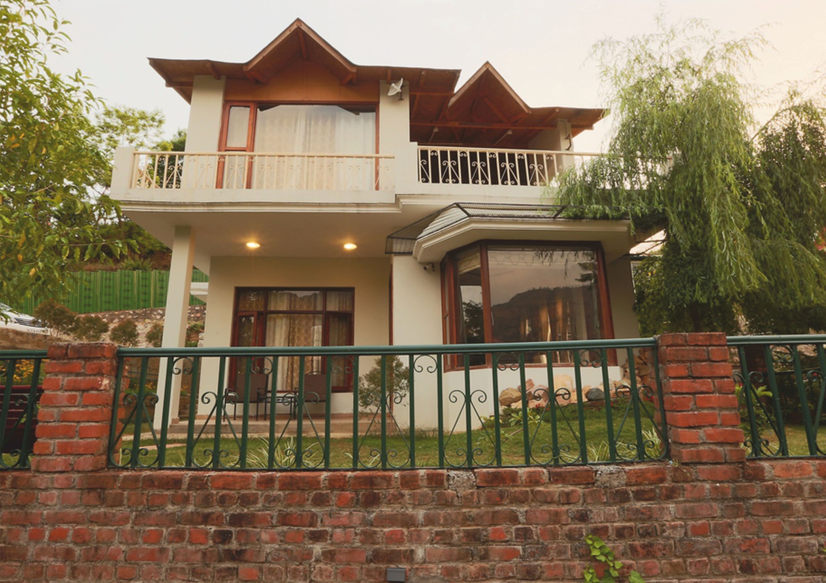 A two-story house with a balcony, a front door, and a small porch.