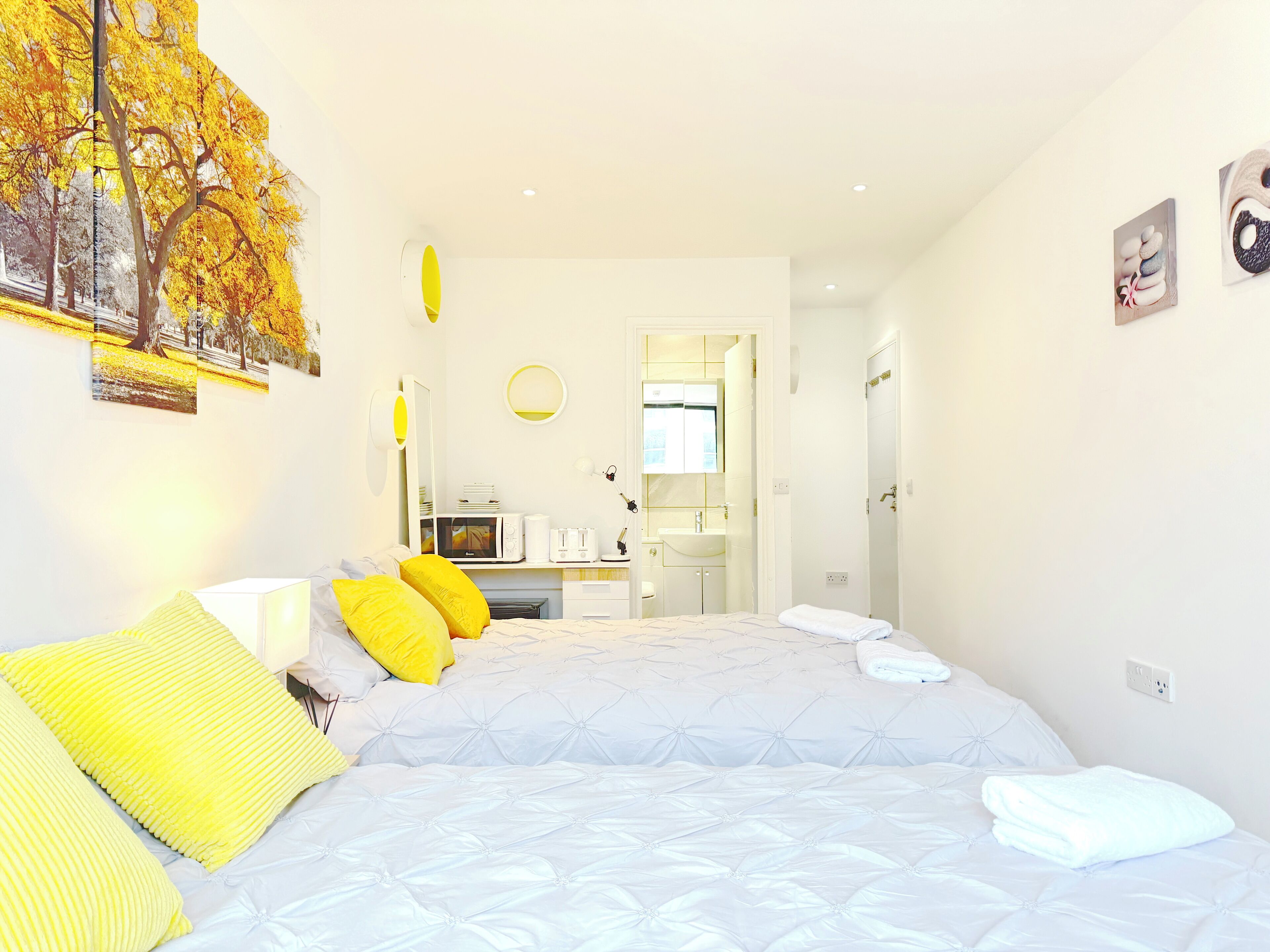A bedroom with a bed, bedside table, and a view into the bathroom.