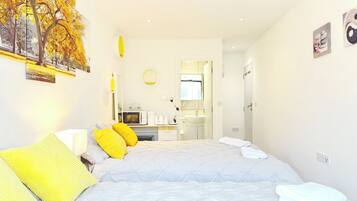 A bedroom with a bed, bedside table, and a view into the bathroom.