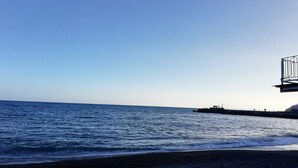 A beach with a rocky shoreline and a pier extending into the water. - Nice apartment on the Amalfi Coast and close to the Path of the Gods (Pianillo)