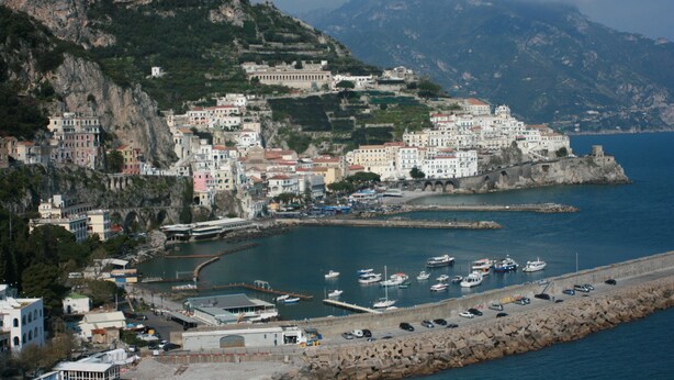 A coastal town with buildings on a hillside overlooking the sea, a marina with boats, and a rocky breakwater. - Nice apartment on the Amalfi Coast and close to the Path of the Gods (Pianillo)